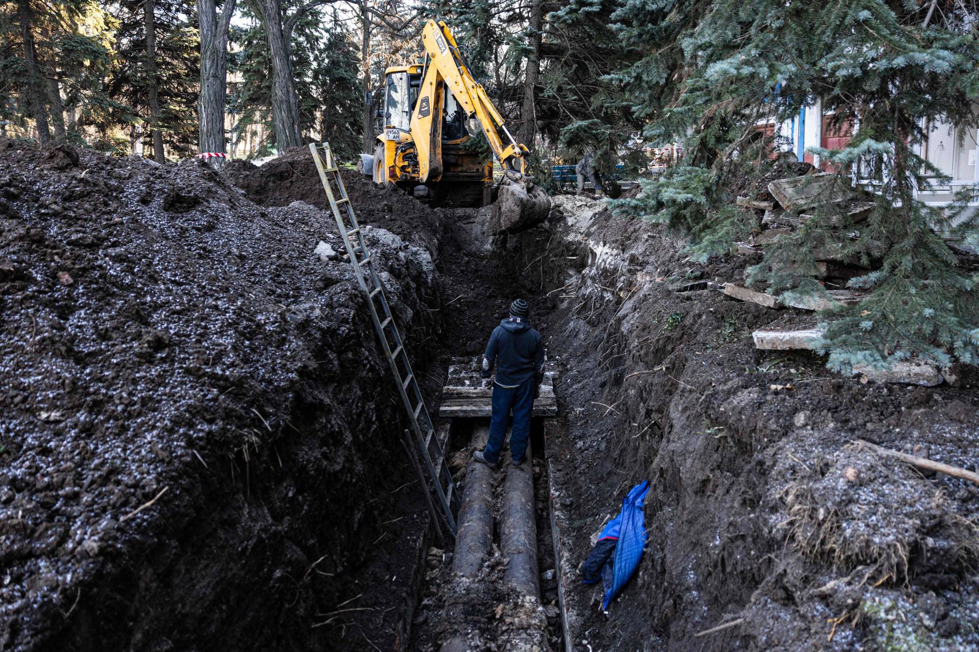 Technicians repair heating pipes damaged during Russian shelling in the city of Kramatorsk, eastern Ukraine, on Monday, as energy operator Ukrenergo announced that emergency electricity outages were scheduled in the capital and nearly a dozen regions. | AFP-JIJI
