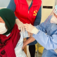A medical worker administers a COVID-19 vaccine to an elderly resident in Zhongmin village on the outskirts of Shanghai on Wednesday. | REUTERS