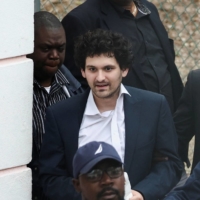 FTX founder Sam Bankman-Fried is escorted out of the Magistrate Court building in Nassau in the Bahamas on Wednesday. | REUTERS