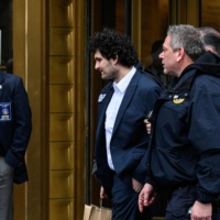 FTX founder Sam Bankman-Fried leaves court following his arraignment in New York City on Thursday. New York judge Gabriel Gorenstein ordered Bankman-Fried be released on $250 million bail. | AFP-JIJI