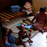 S. Saksan, 5, who has been diagnosed with leukemia, sits with his two grandmothers K. Wimalesvari, 63, and Ratnasingham Rajini, 45, at a cancer center near a hospital in Colombo.  | REUTERS