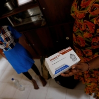Sudhagaran Punawadee, 30, shows a pack of medicine prescribed to her daughter Sudhagaran Sadurshana, 9, who has been diagnosed with acute myeloid leukemia, in August.  | REUTERS