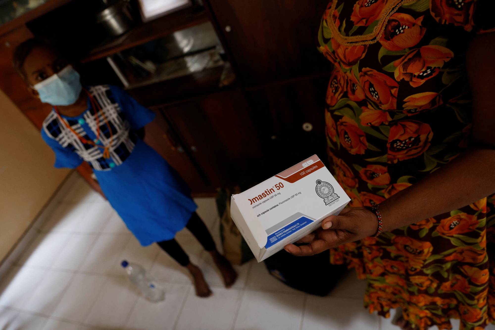 Sudhagaran Punawadee, 30, shows a pack of medicine prescribed to her daughter Sudhagaran Sadurshana, 9, who has been diagnosed with acute myeloid leukemia, in August. | Reuters