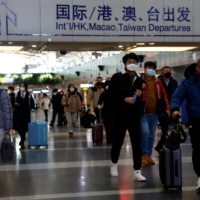 Travelers at Beijing Capital International Airport in Beijing on Tuesday | REUTERS