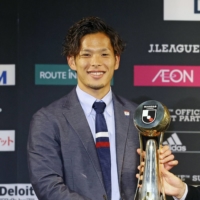 F. Marinos defender Tomoki Iwata receives the trophy for J. League player of the year in Tokyo on Nov. 7. | KYODO