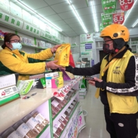 A delivery driver collects medicine at a pharmacy in Danzhai county, in China\'s southwestern Guizhou province, on Dec. 16.    | AFP-JIJI