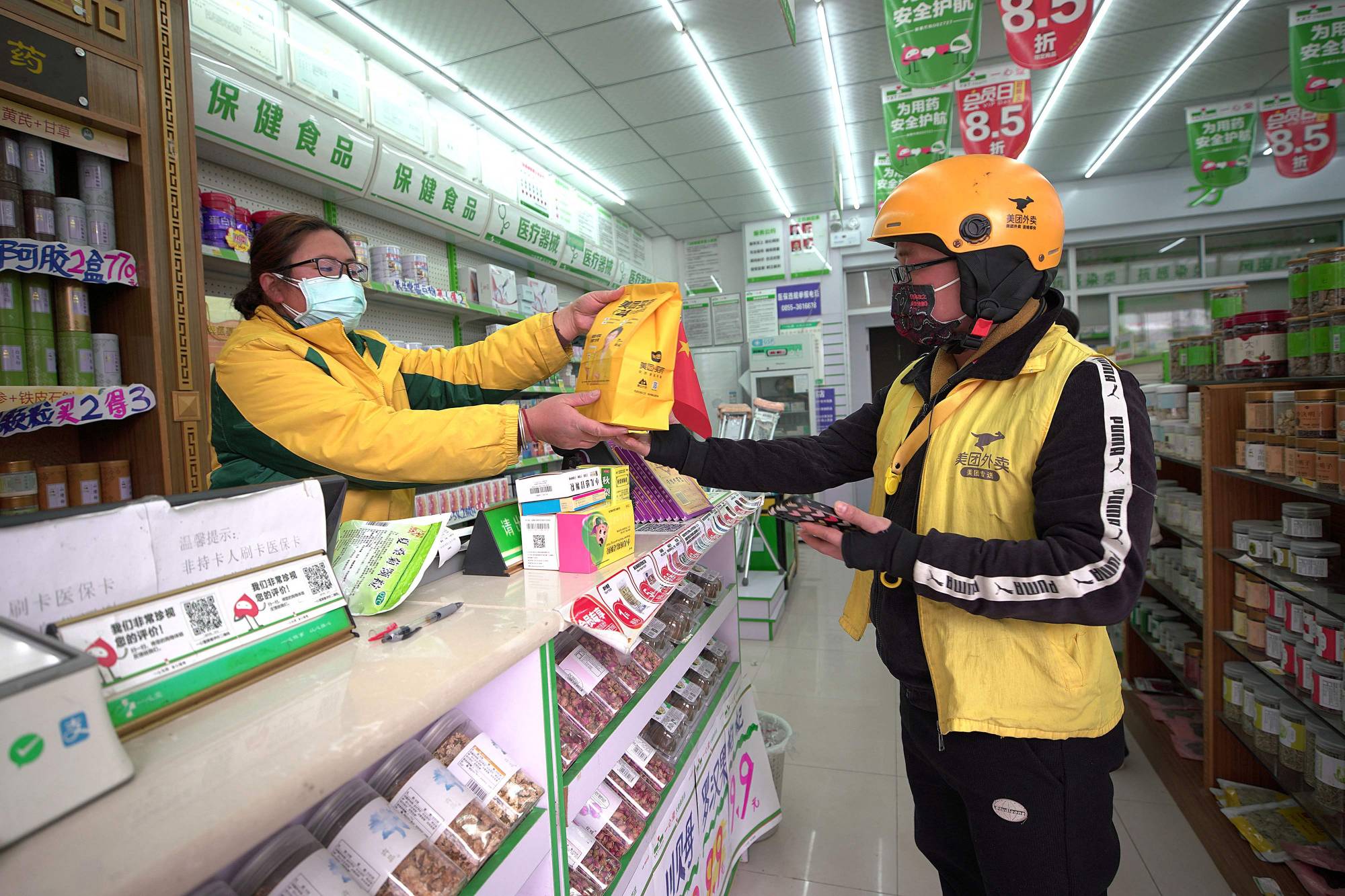 A delivery driver collects medicine at a pharmacy in Danzhai county, in China's southwestern Guizhou province, on Dec. 16. | AFP-Jiji