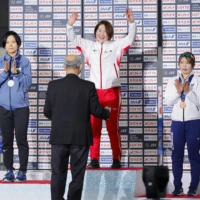Momoka Horikawa celebrates on the podium alongside runner-up Miho Takagi and third-place finisher Ayano Sato after the women\'s 3,000 meters at the national championships in Hachinohe, Aomori Prefecture, on Thursday. | KYODO