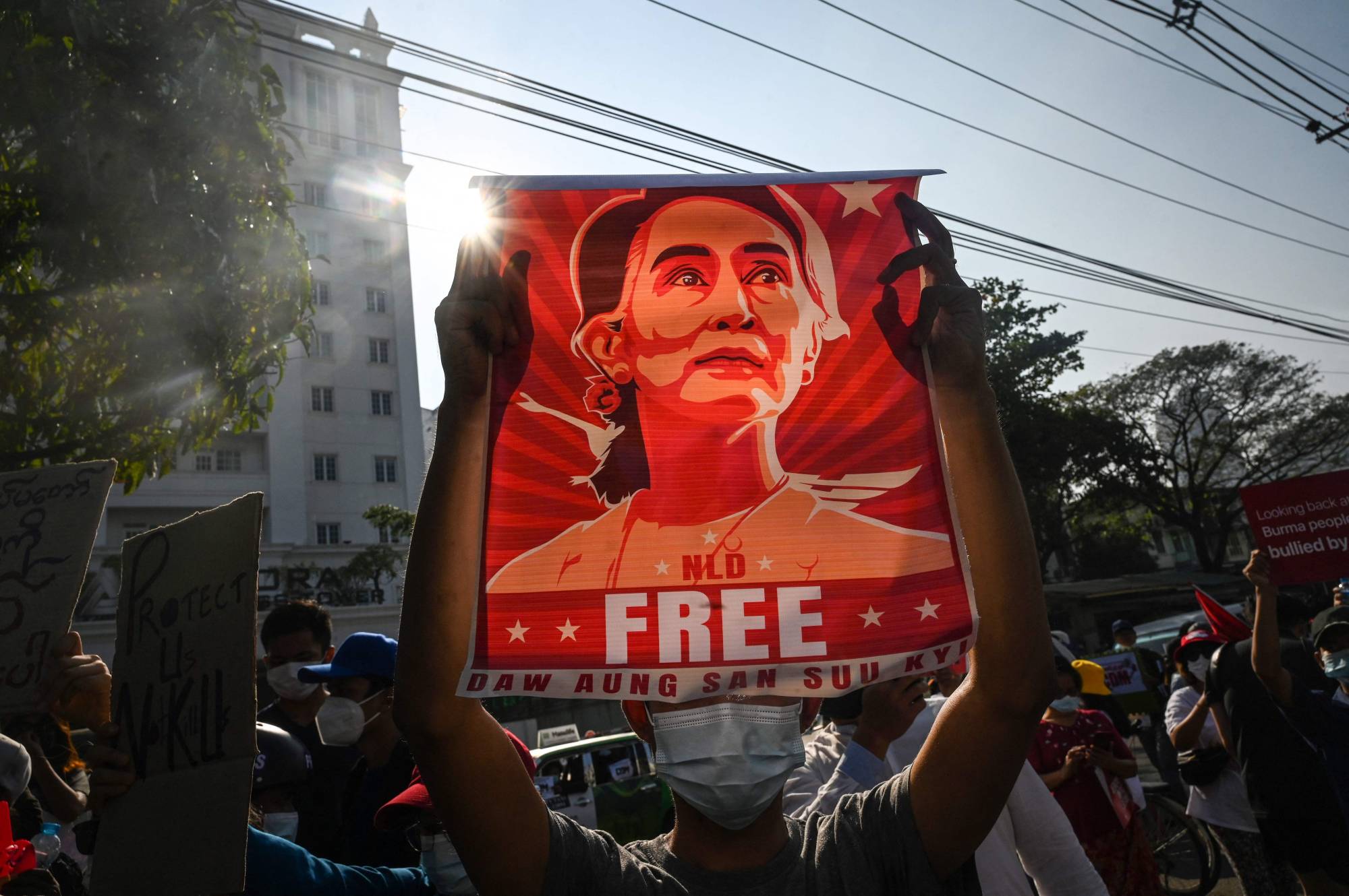 A protester holds up a poster featuring Aung San Suu Kyi during a demonstration against Myanmar's military coup, in Yangon in February 2021.  | AFP-JIJI