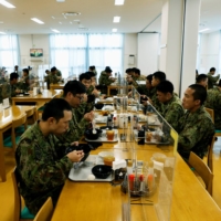 Ground Self-Defense Force members have lunch at a mess hall at their camp on Miyako Island in Okinawa Prefecture in April. | REUTERS