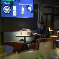 A barkeeper uses a laptop computer inside CryptoBar P2P in the Ginza district of Tokyo in June. | BLOOMBERG