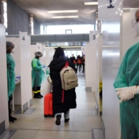 A traveler from a flight from China walks through COVID-19 testing booths at the Paris-Charles-de-Gaulle airport in Roissy, outside Paris, on Sunday. | AFP-JIJI