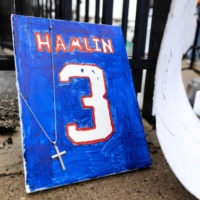 Fans placed items outside University of Cincinnati Medical Center on Tuesday during a vigil for Bills safety Damar Hamlin, who suffered a cardiac arrest during his team\'s game on Monday night in Cincinnati. | REUTERS