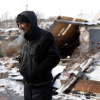 A man smokes a cigarette after emerging from his underground shelter during a bombardment in Bakhmut, Ukraine, on Tuesday.  | REUTERS
