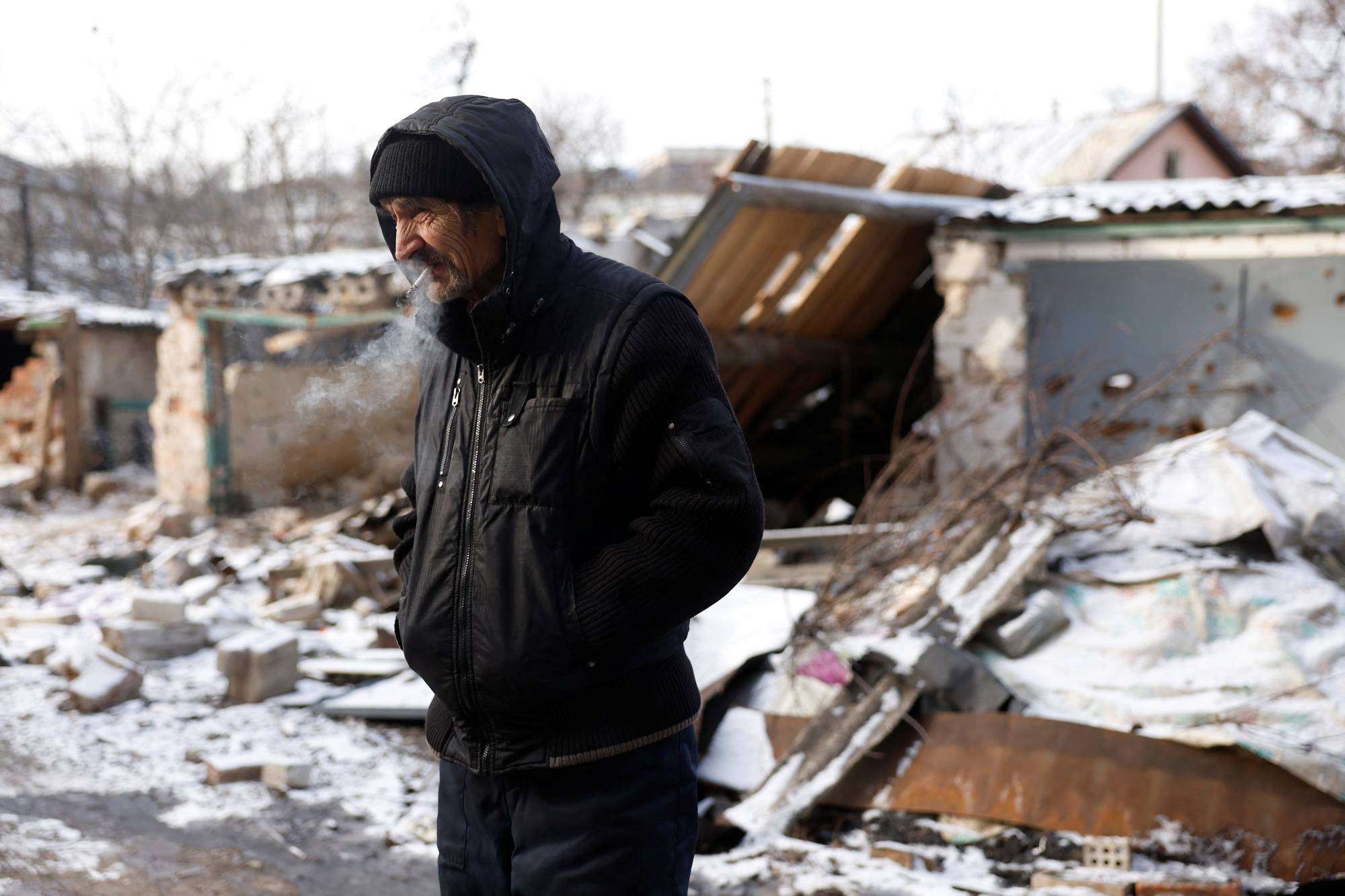 A man smokes a cigarette after emerging from his underground shelter during a bombardment in Bakhmut, Ukraine, on Tuesday. | Reuters