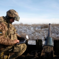 A member of the Ukrainian military receives coordinates before firing an anti-aircraft weapon in Bakhmut, Ukraine, on Tuesday. | REUTERS