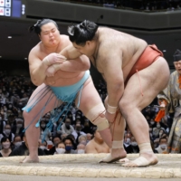 Kotonowaka (left) grapples with Takayasu on Day 5 of the New Year Grand Sumo Tournament at Ryogoku Kokugikan on Thursday. | KYODO