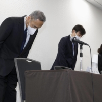 Astronaut Satoshi Furukawa (left) bows in apology at a news conference in Tokyo on Thursday. | KYODO