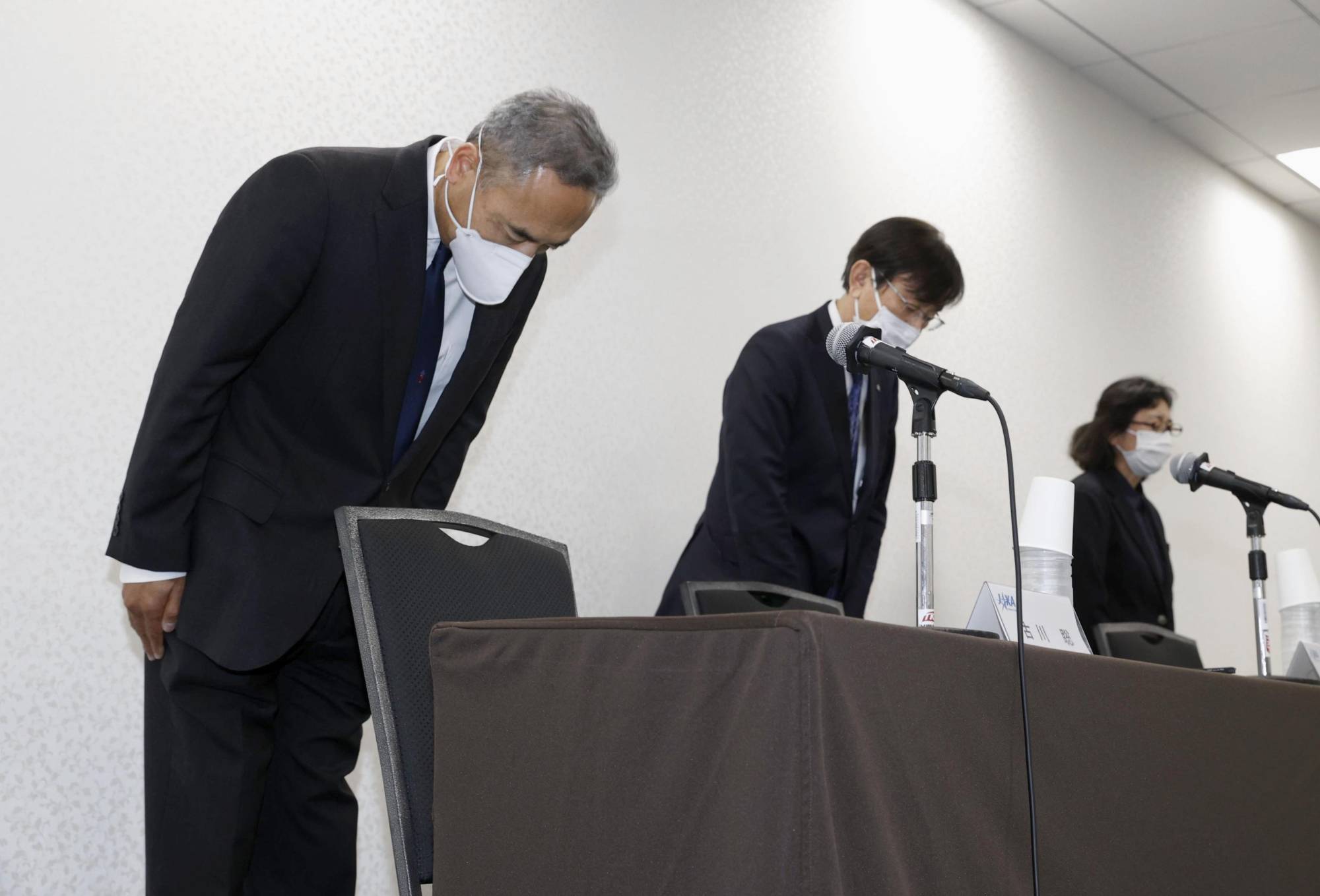 Astronaut Satoshi Furukawa (left) bows in apology at a news conference in Tokyo on Thursday. | KYODO