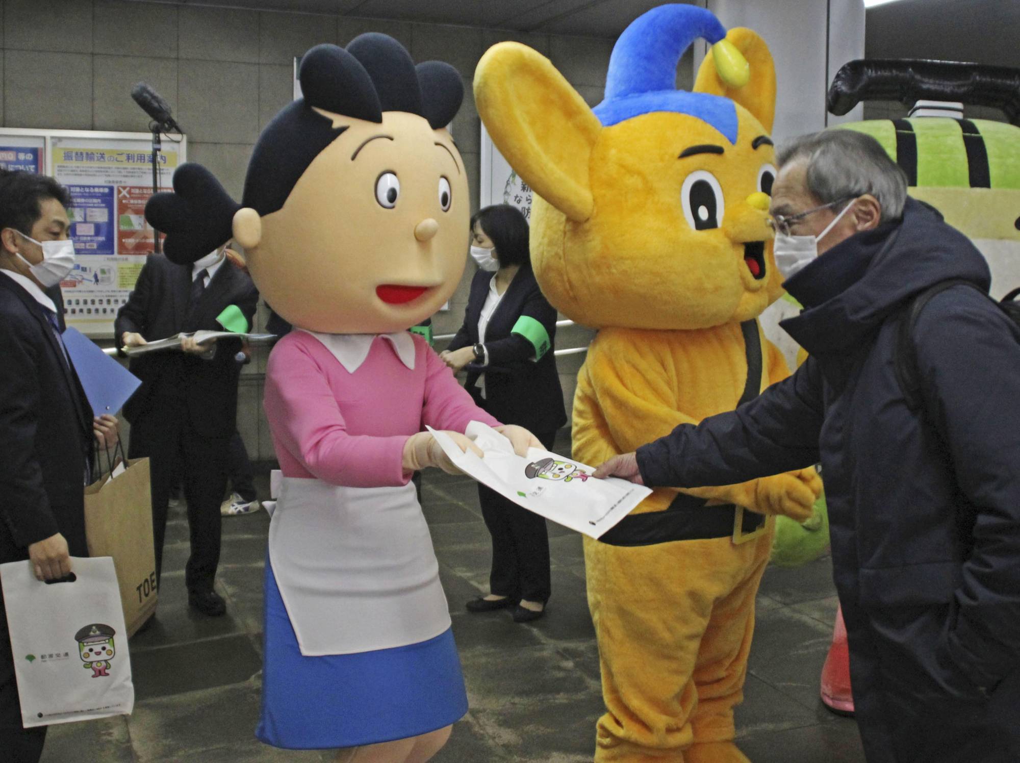Anime character Sazae-san hands out flyers to raise awareness of groping on trains ahead of the unified college entrance exam at the weekend, at Tokyo's Shinjuku Station on Wednesday. | KYODO