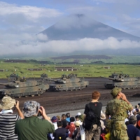 Japan Ground Self-Defense Force tanks take part in a live-fire exercise in Shizuoka Prefecture in August 2019.   | BLOOMBERG