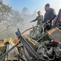 Rescuers gather at the site of a plane crash in Pokhara, Nepal, on Sunday.  | AFP-JIJI