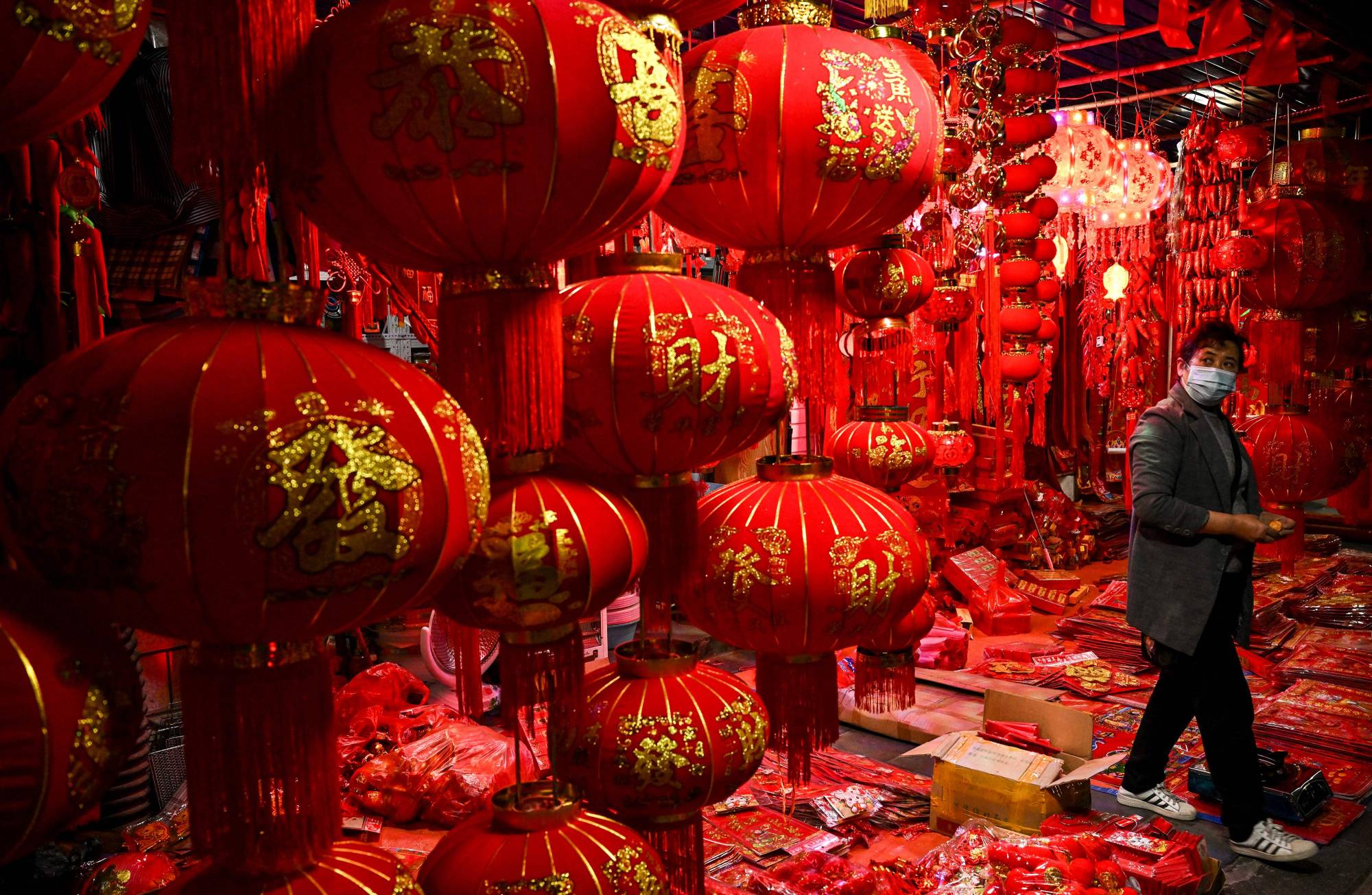 A vendor looks on at Chinese lanterns at a shop in Ruili, China, on Friday. | AFP-JIJI