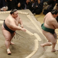 Takakeisho (left) forces out Sadanoumi during their Day 9 bout at Ryogoku Kokugikan on Monday. | KYODO