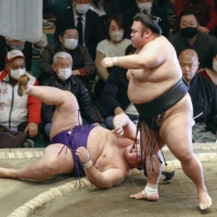 Takakeisho (right) defeats Meisei to retain his lead at the New Year Grand Sumo Tournament on Tuesday. | KYODO