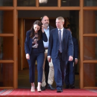 Then-New Zealand Prime Minister Jacinda Ardern walks with incoming Labor leader Chris Hipkins at Parliament House in Wellington on Sunday. | AAP IMAGE / VIA REUTERS  