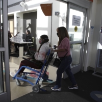 A long COVID-19 patient is brought by her mother into a hospital in Sacramento, California in October 2021.  | JIM WILSON / THE NEW YORK TIMES