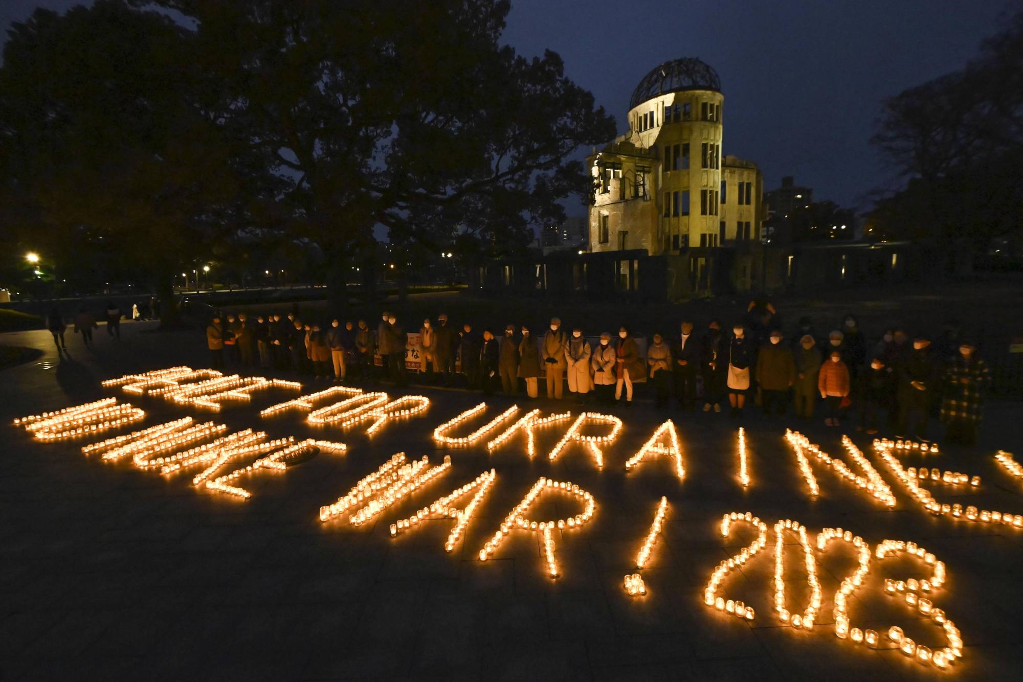 The message 'Peace for Ukraine' is spelled out in candles at Peace Memorial Park in Hiroshima on Sunday to mark the second anniversary of the Treaty on the Prohibition of Nuclear Weapons going into effect. | KYODO