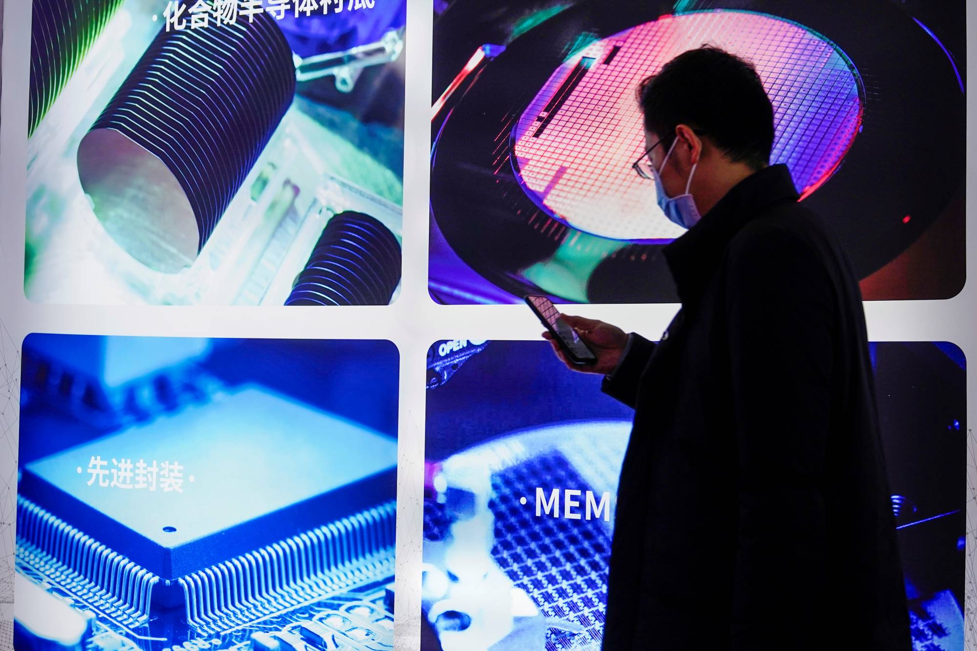 A man visits a display of semiconductor devices at Semicon China, a trade fair for semiconductor technology, in Shanghai in March 2021. | REUTERS
