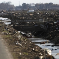 A member of the Self-Defense Forces walks along an area devastated by the Great East Japan Earthquake and tsunami, in Sendai on April 16, 2011.  | REUTERS