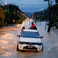 A pickup truck wades through a flooded area following heavy rainfall in Klang in Malaysia\'s Selangor state on Nov. 10 last year. | REUTERS