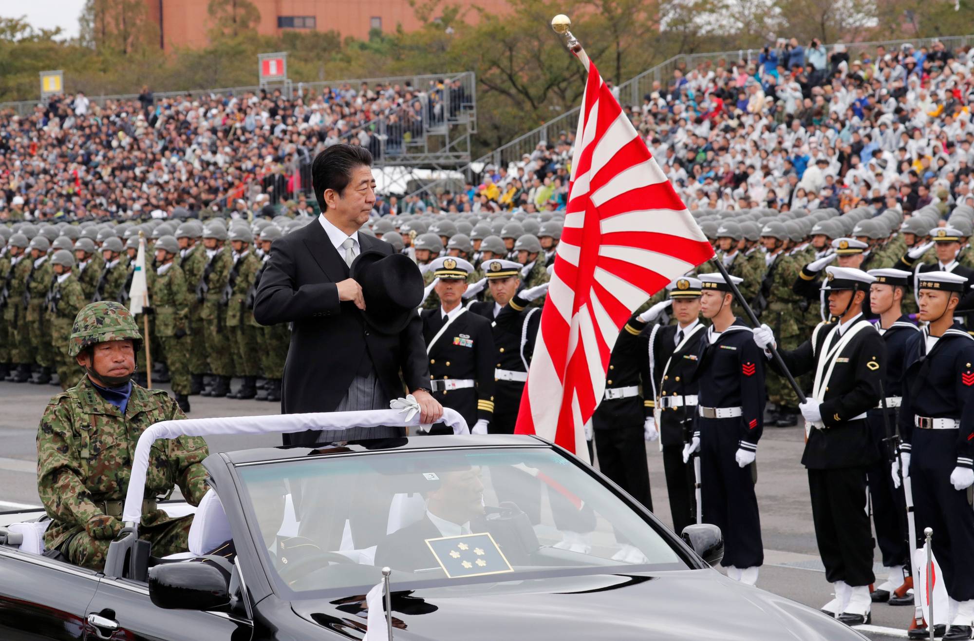 Then-Prime Minister Shinzo Abe reviews Self-Defense Force troops during a ceremony at Asaka Base north of Tokyo in October 2018. | REUTERS