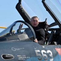 NATO Secretary-General Jens Stoltenberg gets into the cockpit of an Air Self-Defense Force F-2 fighter jet during an inspection at the Iruma Air Base in Sayama, Saitama Prefecture, on Tuesday. | AFP-JIJI