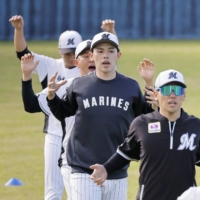 Marines pitcher Roki Sasaki (center) works out with teammates on the first day of Nippon Professional Baseball\'s spring training in Ishigaki, Okinawa Prefecture, on Wednesday.  | KYODO