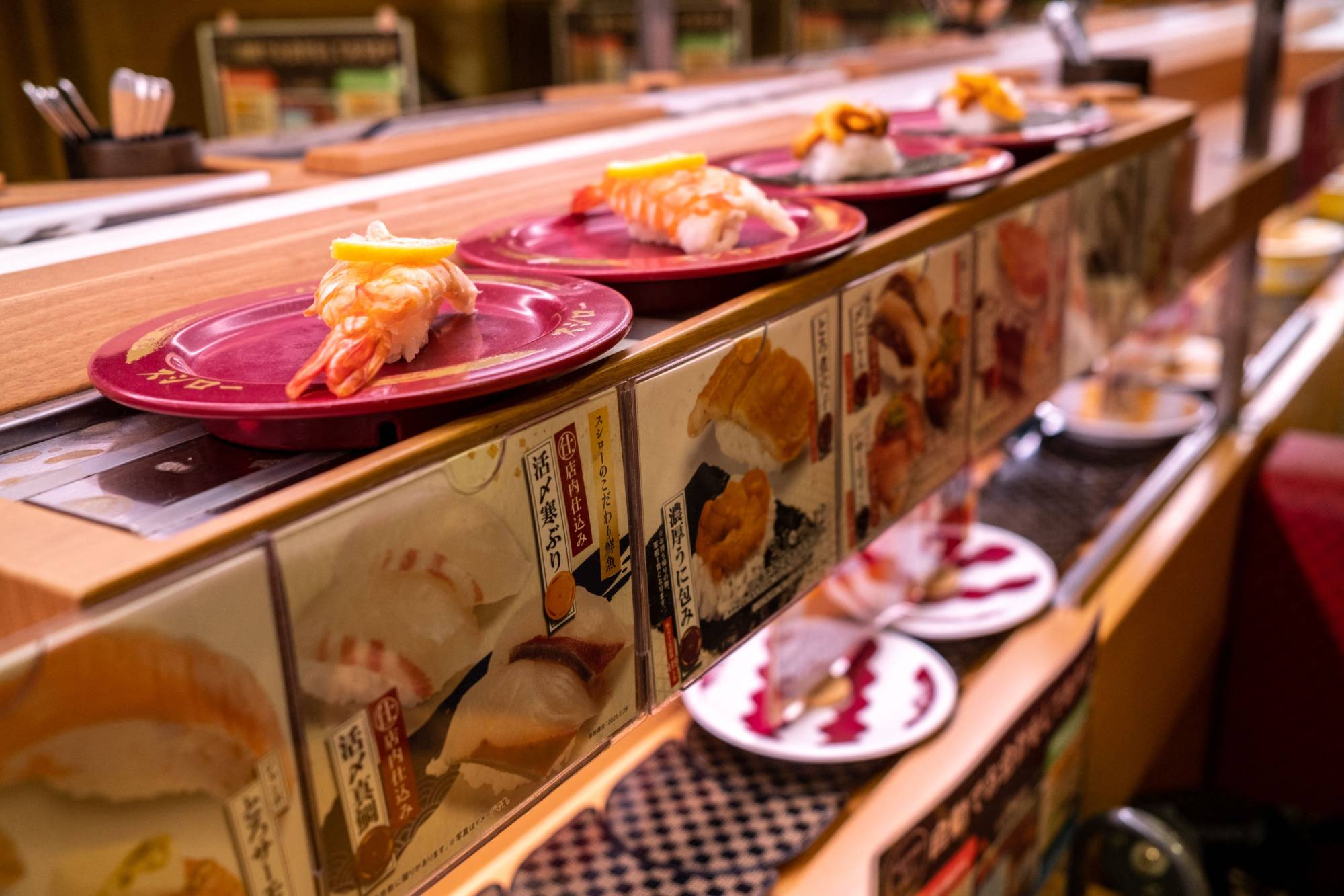 Plates of sushi are seen on a conveyor belt at a sushi chain restaurant in Tokyo on Friday. | AFP-JIJI