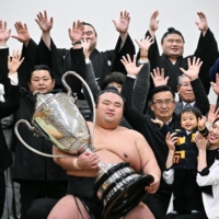 Takakeisho (center) could earn promotion to yokozuna if he follows his New Year Grand Sumo Tournament victory with a win in Osaka next month. | AFP-JIJI
