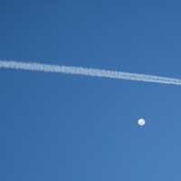 A U.S. fighter jet flies by a suspected Chinese spy balloon before the balloon was shot down off the coast of Surfside Beach, South Carolina, on Saturday. | REUTERS