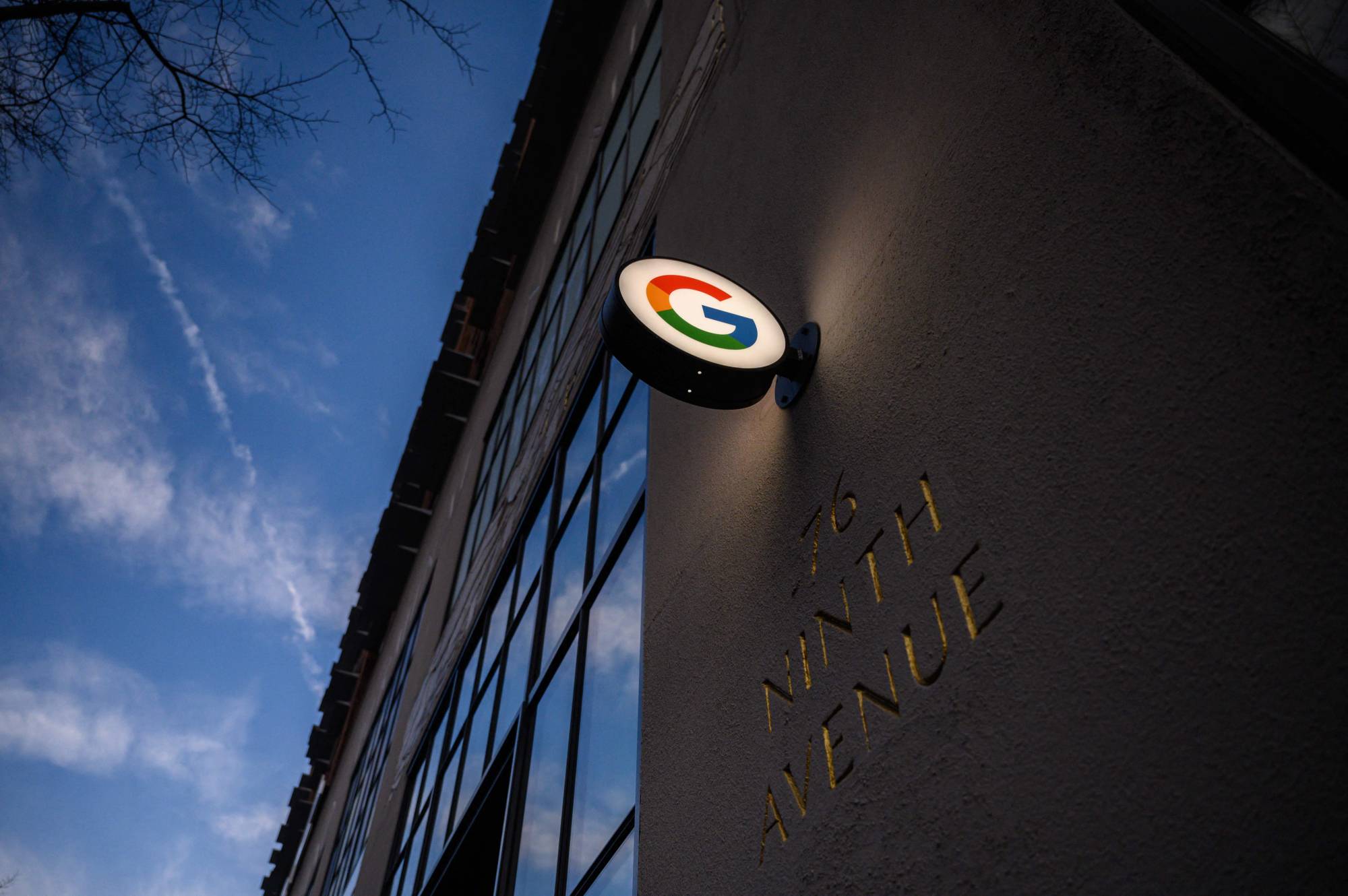 A Google sign illuminated as members of the Alphabet Workers Union (CWA) hold a rally outside the Google offic,e in response to recent layoffs, in New York on Feb. 2. Google's parent company, Alphabet, announced in January it will cut about 12,000 jobs globally, citing a changing economic reality. | AFP-JIJI