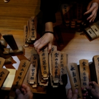 South Korean relatives of workers killed at the Chosei coal mine sort ancestral tablets for the victims at a temple in Ube on Feb. 4. | REUTERS