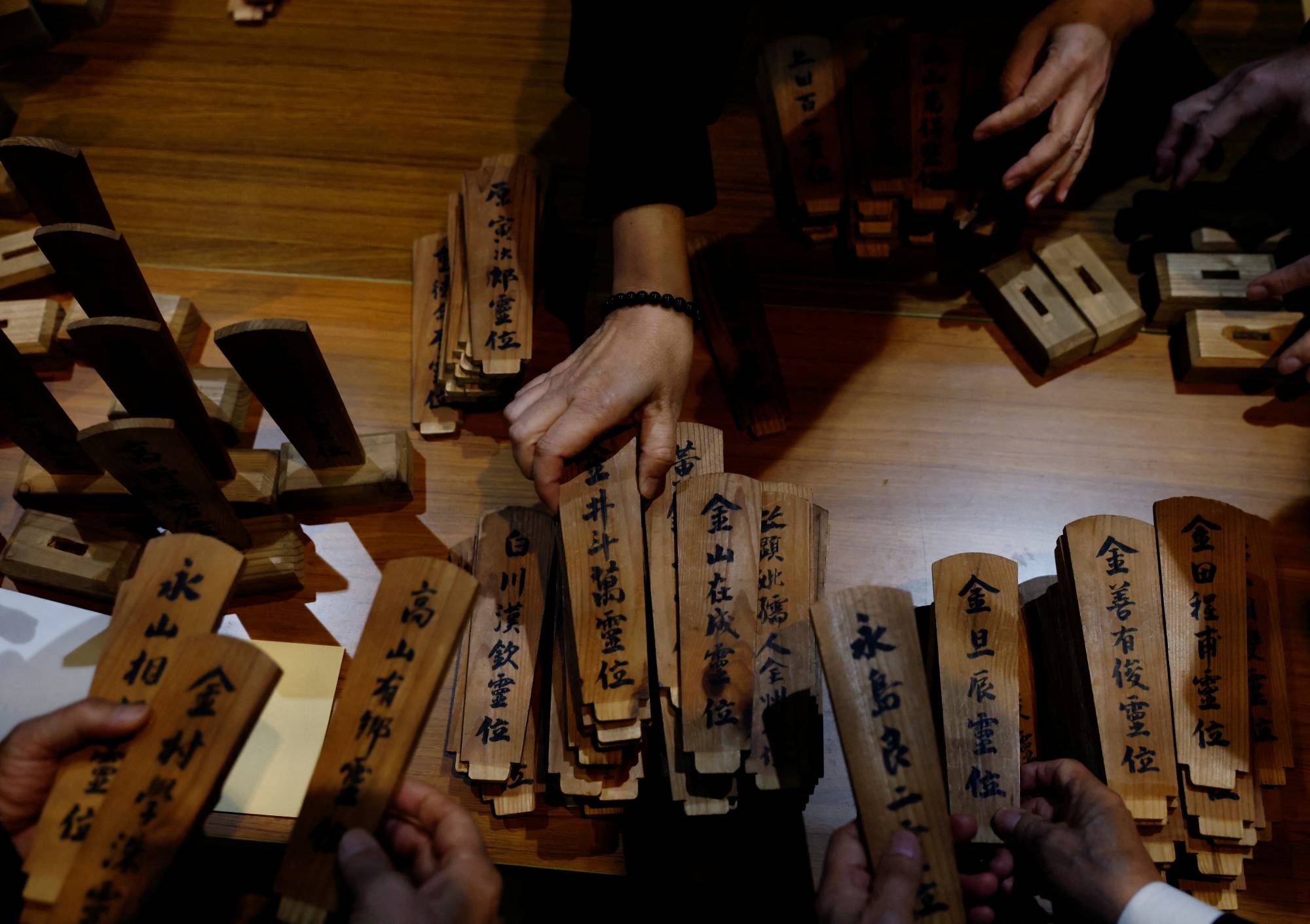 South Korean relatives of workers killed at the Chosei coal mine sort ancestral tablets for the victims at a temple in Ube on Feb. 4. | Reuters