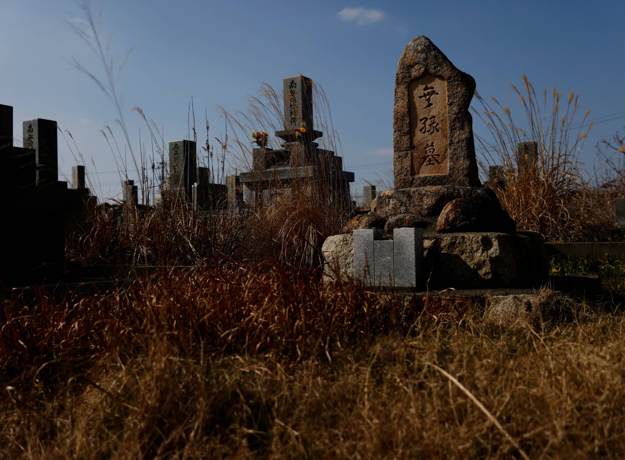 A tombstone for those who have no relatives stands near the Chosei coal mine. A local support group believes it may have been built for the Korean miners killed in the mining disaster. | Reuters