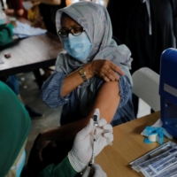 A medical worker prepares a dose of a COVID-19 booster shot in Jakarta in January 2022. | REUTERS 