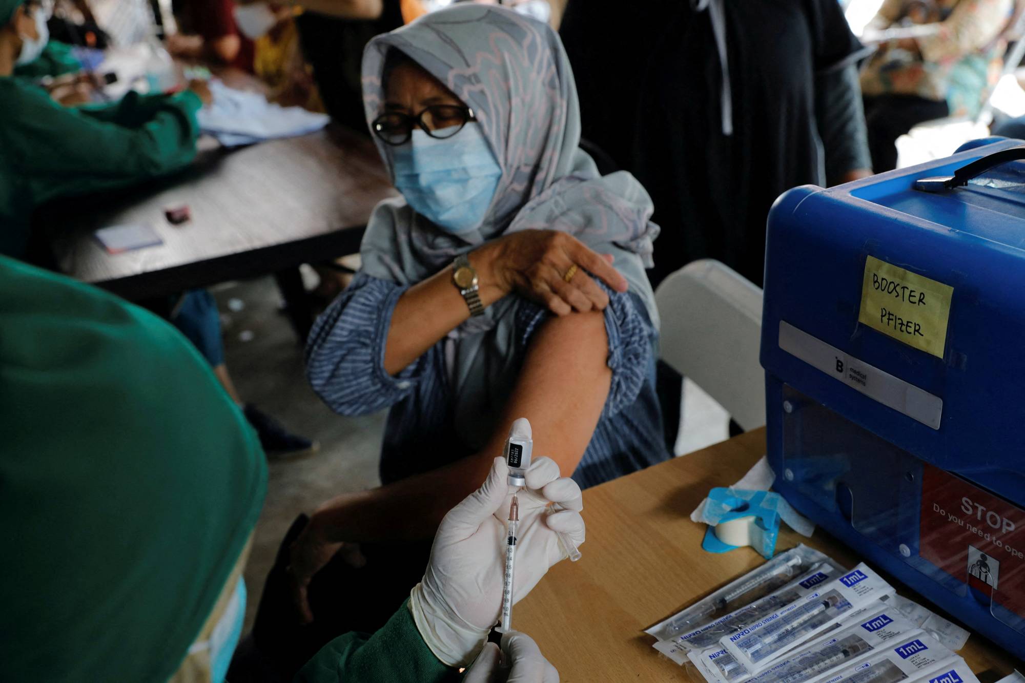 A medical worker prepares a dose of a COVID-19 booster shot in Jakarta in January 2022. | REUTERS 