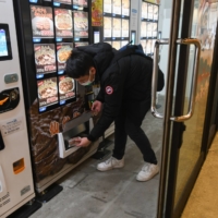 A customer buys a frozen wagyu meal from a vending machine in Tokyo. | BLOOMBERG