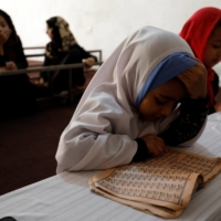 An Afghan girl reads the Quran at a madrassa, or religious school, in Kabul | REUTERS