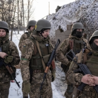 Ukrainian servicemen of the 80th Air Assault Brigade stand in front of a Bushmaster Protected Mobility Vehicle, near Bahmut in the Donetsk region of Ukraine on Thursday. | REUTERS